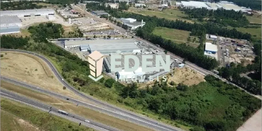 Fachada de galpão industrial de grande porte com estacionamento externo, localizado em Aparecidinha, Sorocaba.