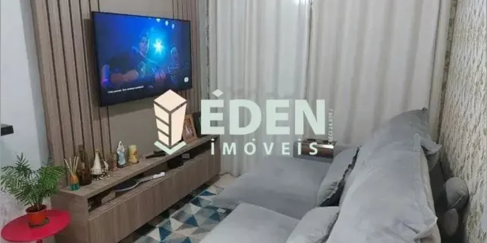 Sala de estar com piso claro, janelas grandes e parede branca em apartamento no bairro Éden em Sorocaba
